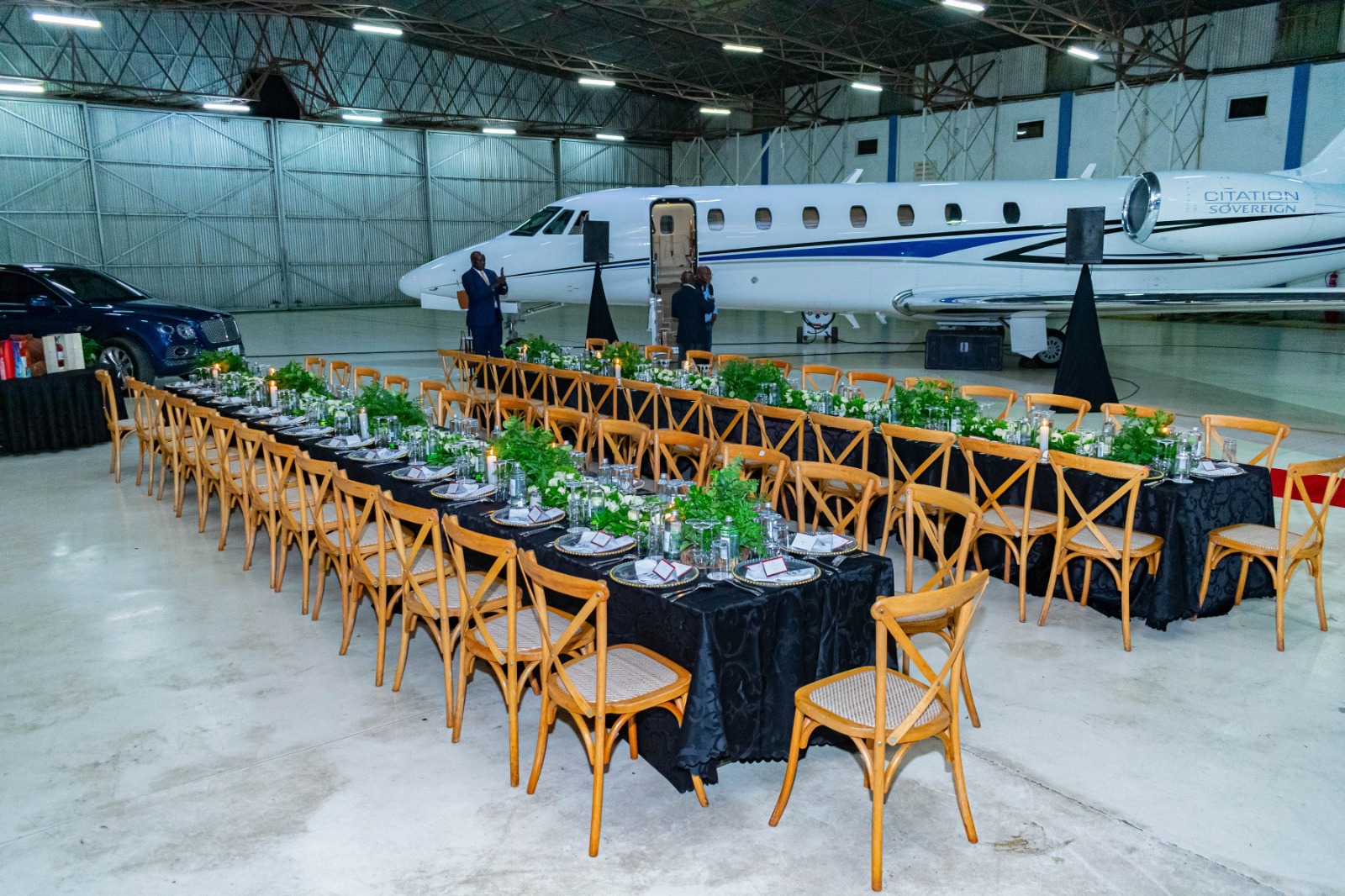Luxurious private event setup inside an aircraft hangar by Kokoro Group Kenya, featuring elegant dining tables, premium décor, and a private jet backdrop.