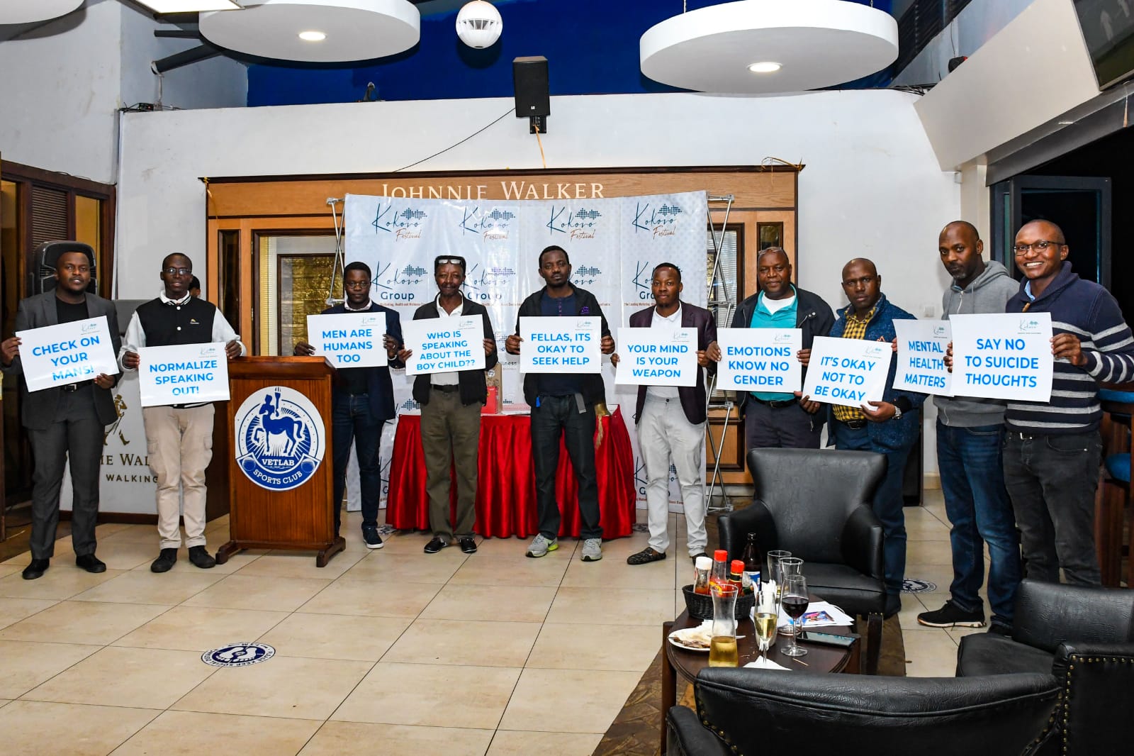 Men holding mental health awareness placards at a Kokoro Group event at Vetlab Sports Club, promoting emotional wellness and suicide prevention.